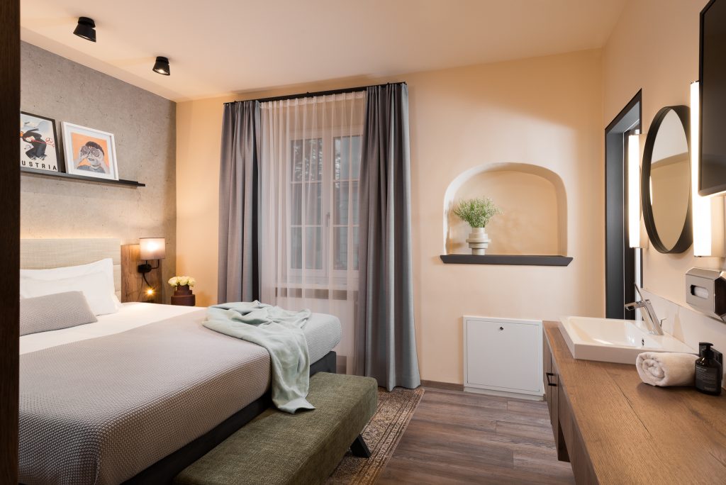 Comfortable bed in the One-Bedroom Open Plan Suite at master Linzergasse, set in a thoughtfully designed open layout for a restful stay.