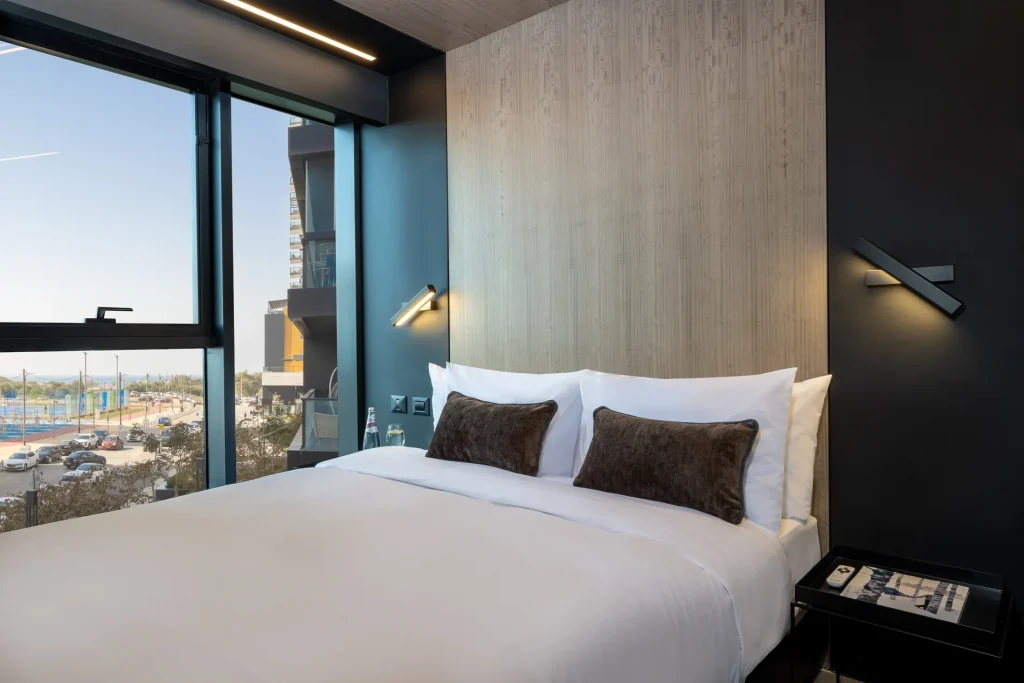 Comfortable bedroom in the One-Bedroom Suite with Sofa Bed at master Bat Yam, featuring a plush bed and a warm, inviting atmosphere.
