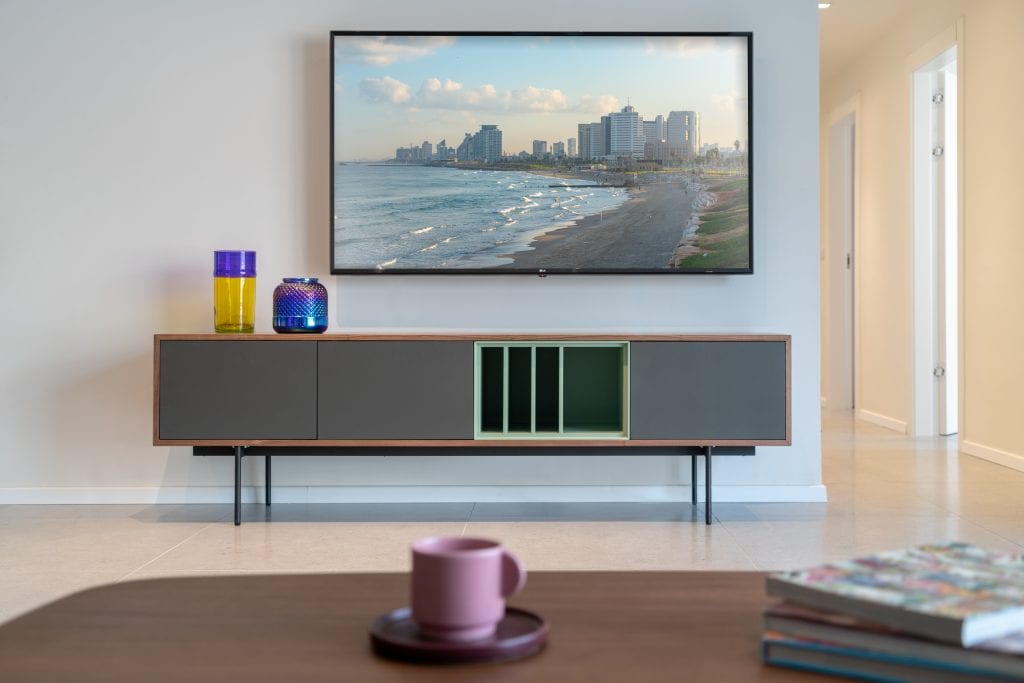 Cozy living area in the Three-Bedroom Apartment with Big Terrace at master Shenkin Tel Aviv, featuring a stylish entertainment setup with a flat-screen TV