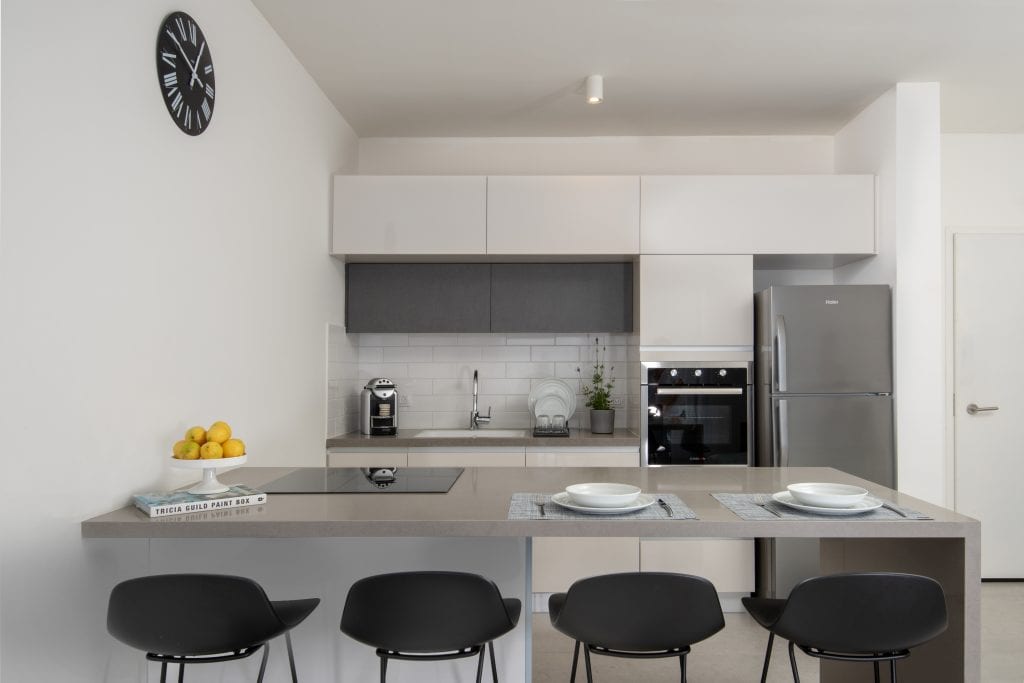 Compact yet functional kitchenette in the Three-Bedroom Apartment at master Shenkin Tel Aviv, blending convenience with a contemporary design.