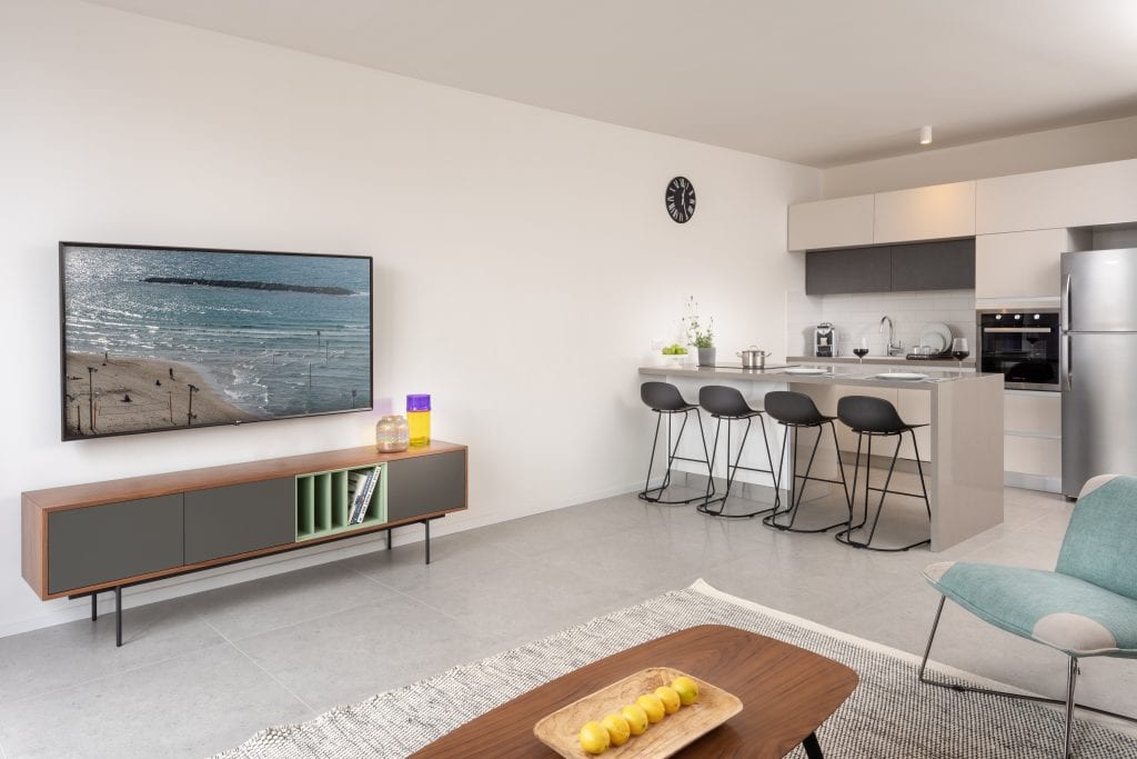 Well-equipped kitchenette in the Three-Bedroom Apartment at master Shenkin Tel Aviv, featuring sleek cabinetry and modern appliances.