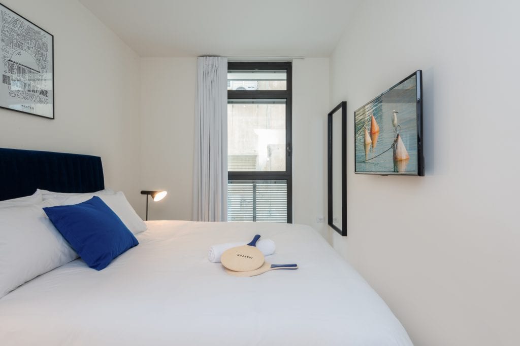 Comfortable bedroom in the One-Bedroom Apartment at master Shenkin Tel Aviv, featuring a plush bed and soft lighting for a relaxing stay.