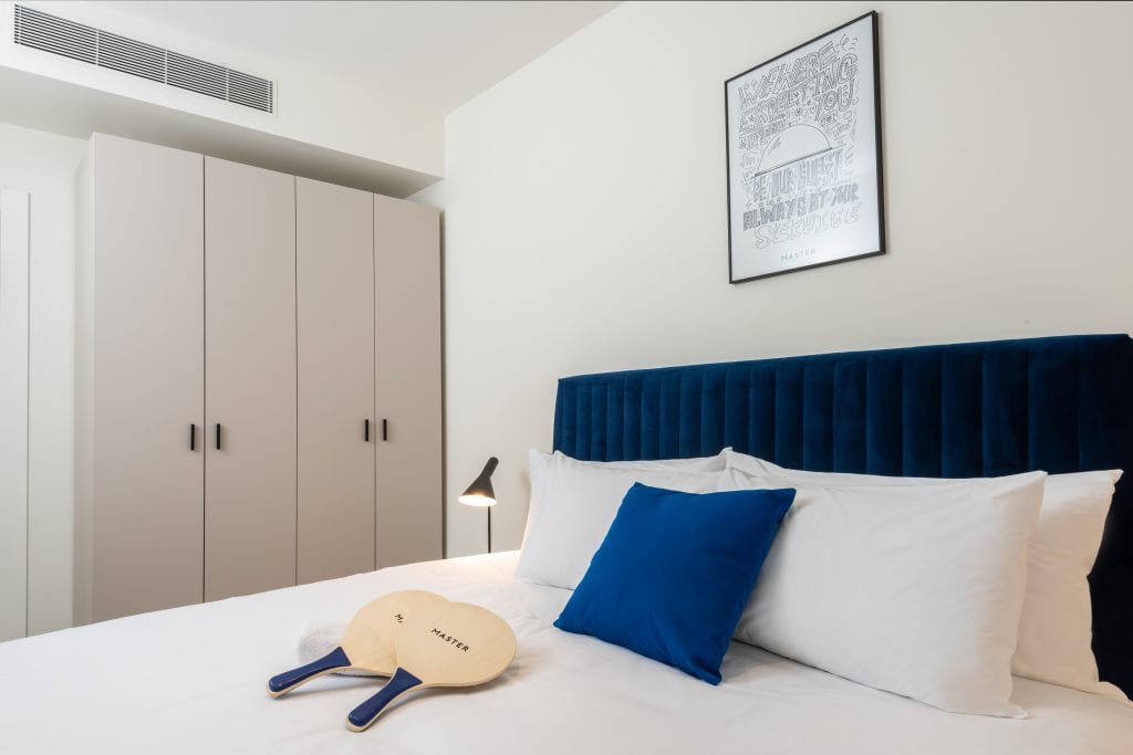 Cozy sleeping area in the One-Bedroom Apartment at master Shenkin Tel Aviv, designed with stylish decor and a well-appointed bed