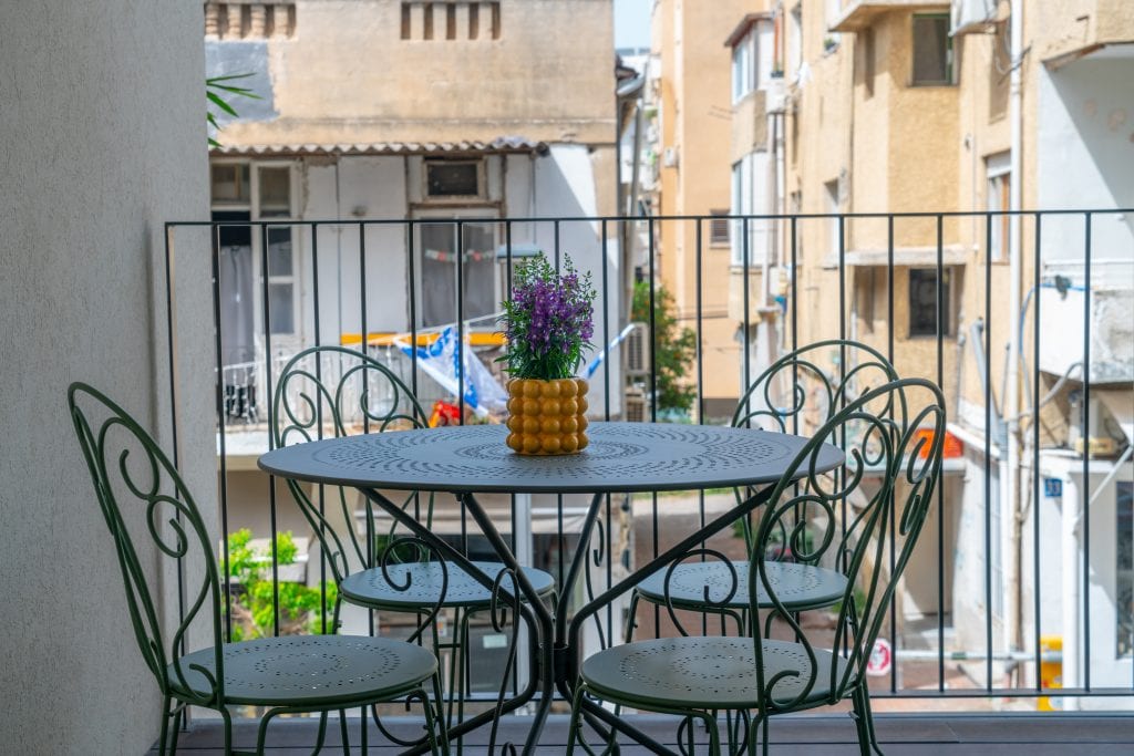 Bright and airy balcony in the Three-Bedroom Apartment at master Shenkin Tel Aviv, providing an inviting spot to unwind.