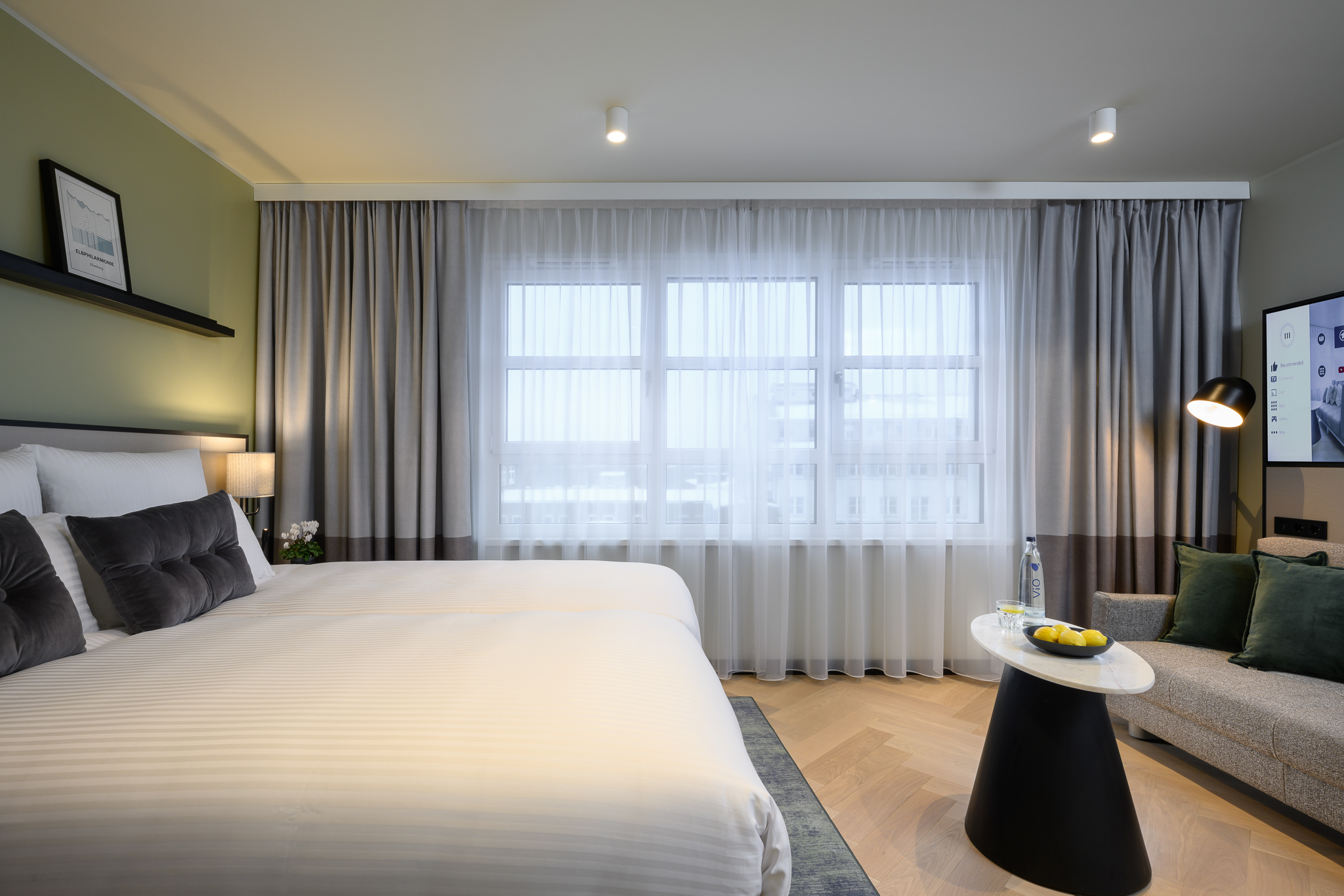 Comfortable and stylish bed in the Studio with Sofa Bed at master Altona Hamburg, offering a relaxing atmosphere with a window view.