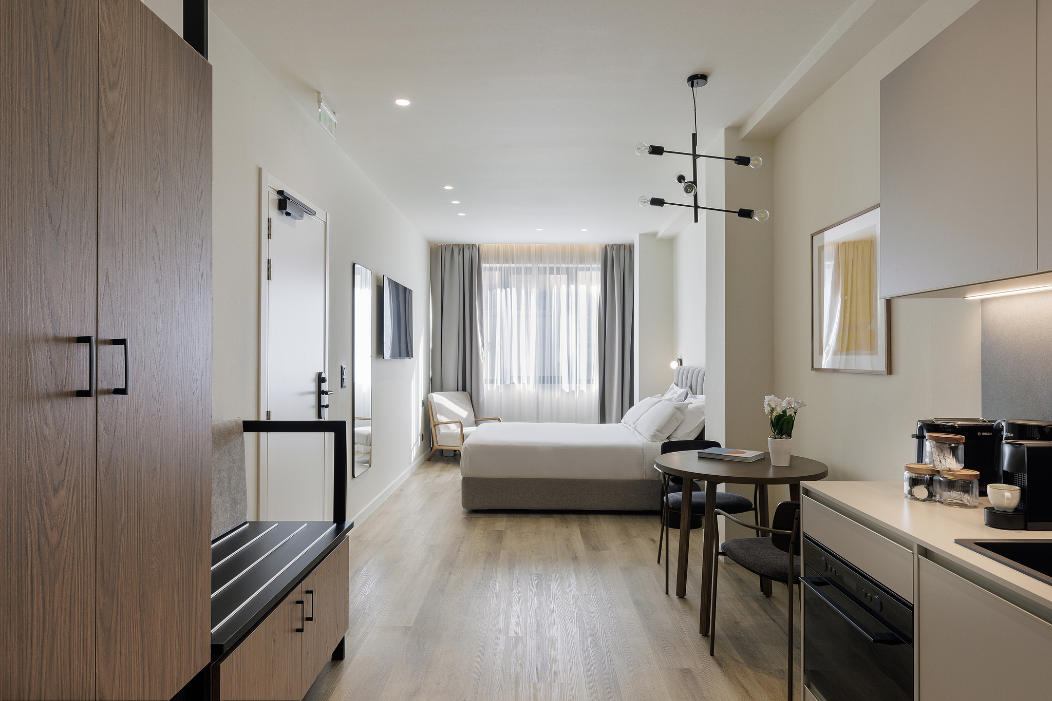 Cozy bed in the Studio Apartment at master Plaka Athens, surrounded by stylish decor in a modern, inviting space.