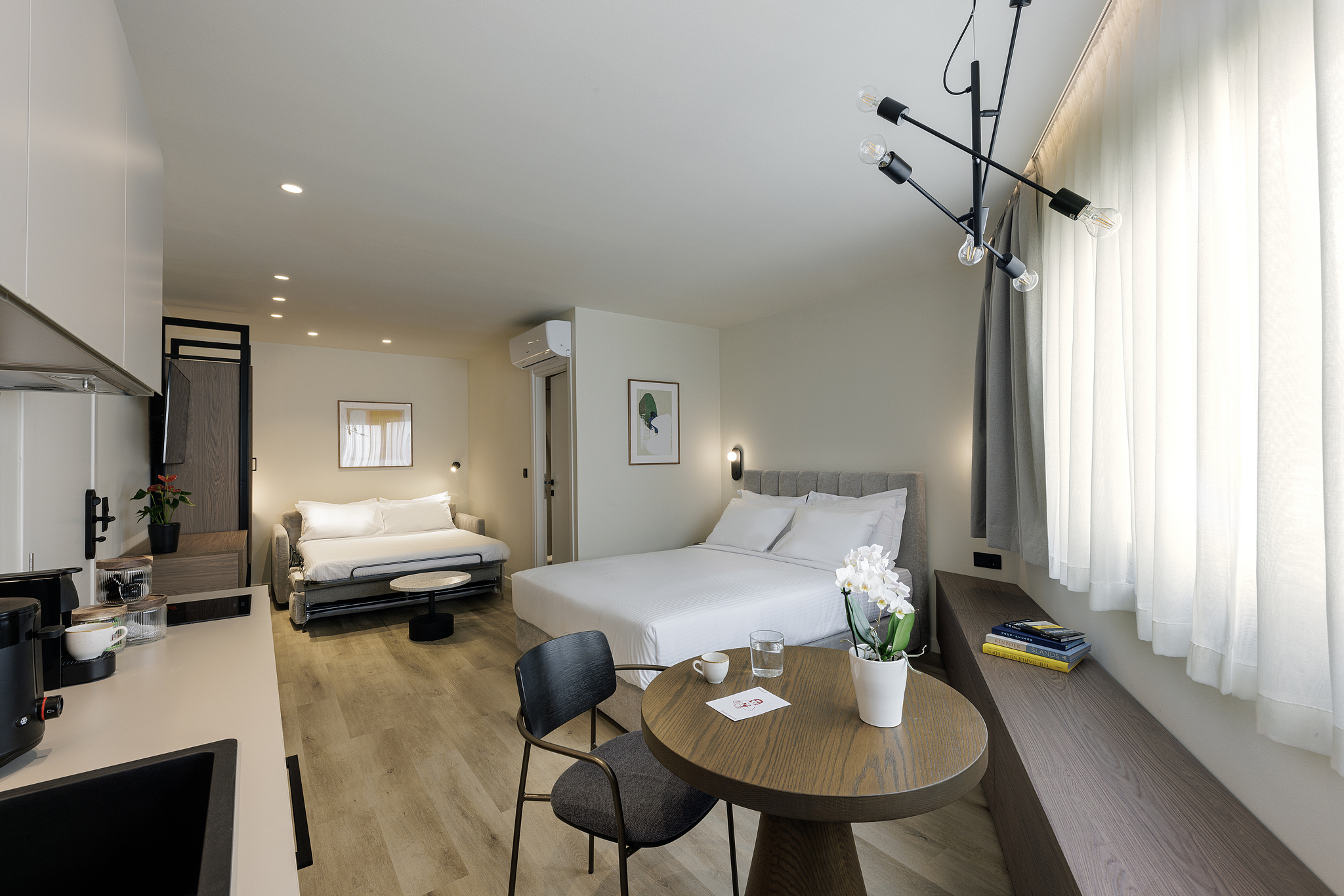 Modern studio at master Plaka Athens featuring a well-appointed bed and a stylish, functional layout.