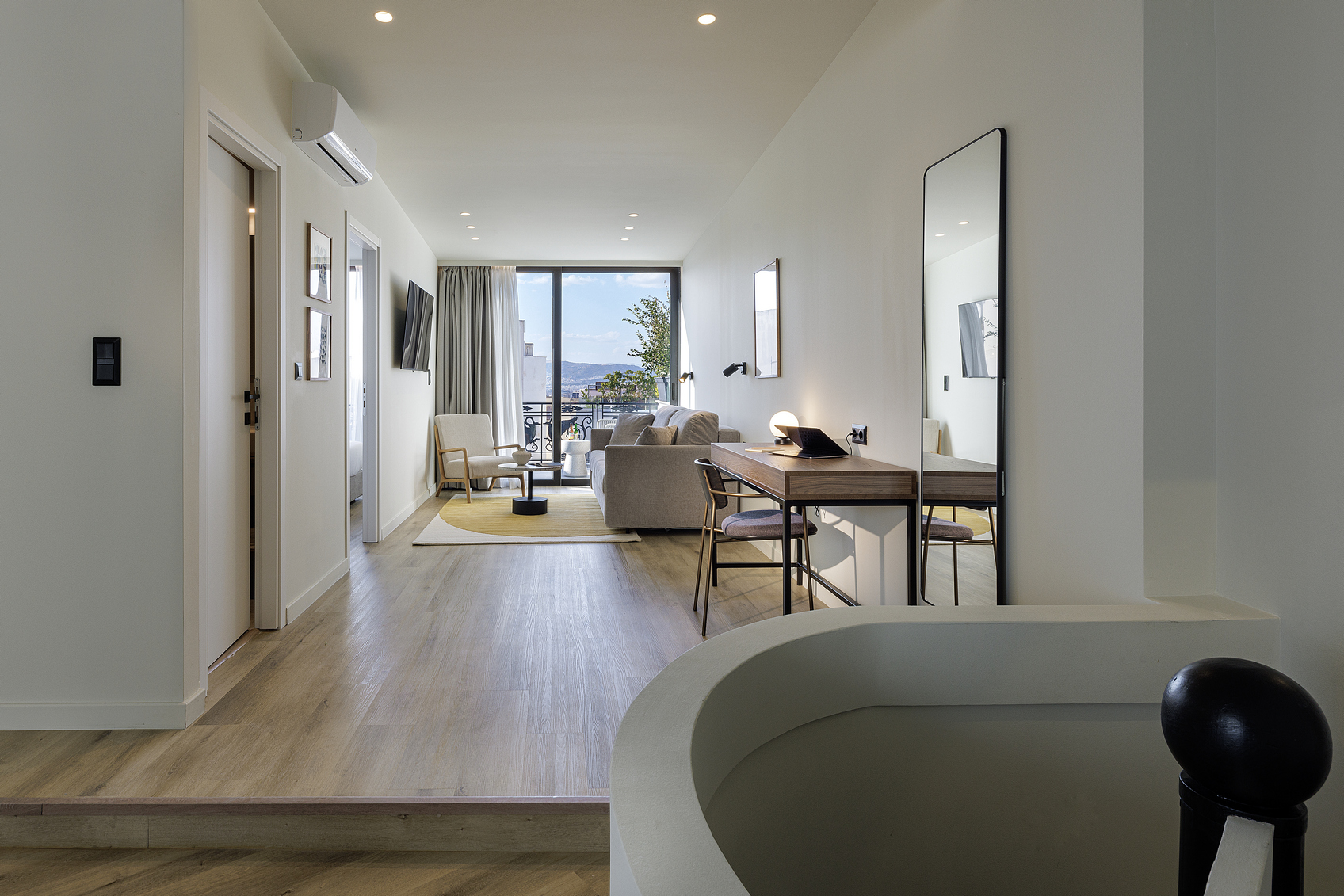 Bright and stylish living space in the One Bedroom Penthouse at master Plaka Athens, seamlessly connecting the cozy sofa area to the outdoor balcony.