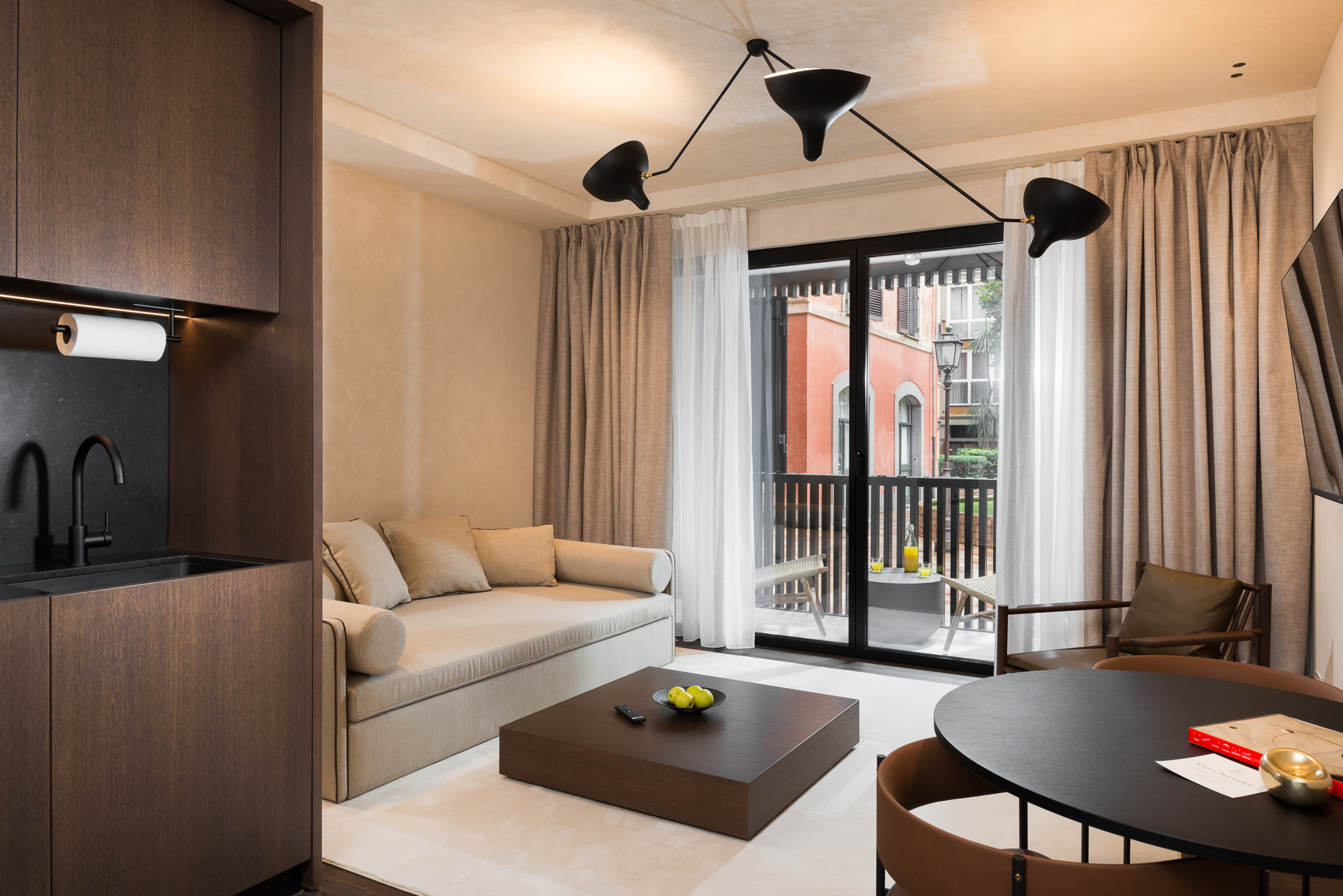 Spacious living area in the Large Studio Ground Level at master Trevi Rome, featuring a stylish seating arrangement with views of the outdoor surroundings.