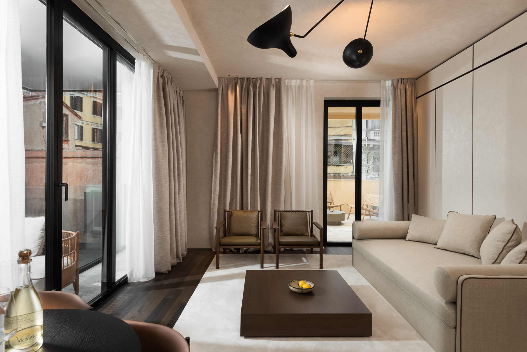 Bright and open living area in the One-Bedroom Apartment with Big Terrace at master Trevi Rome, featuring two entrances leading to the private balcony.