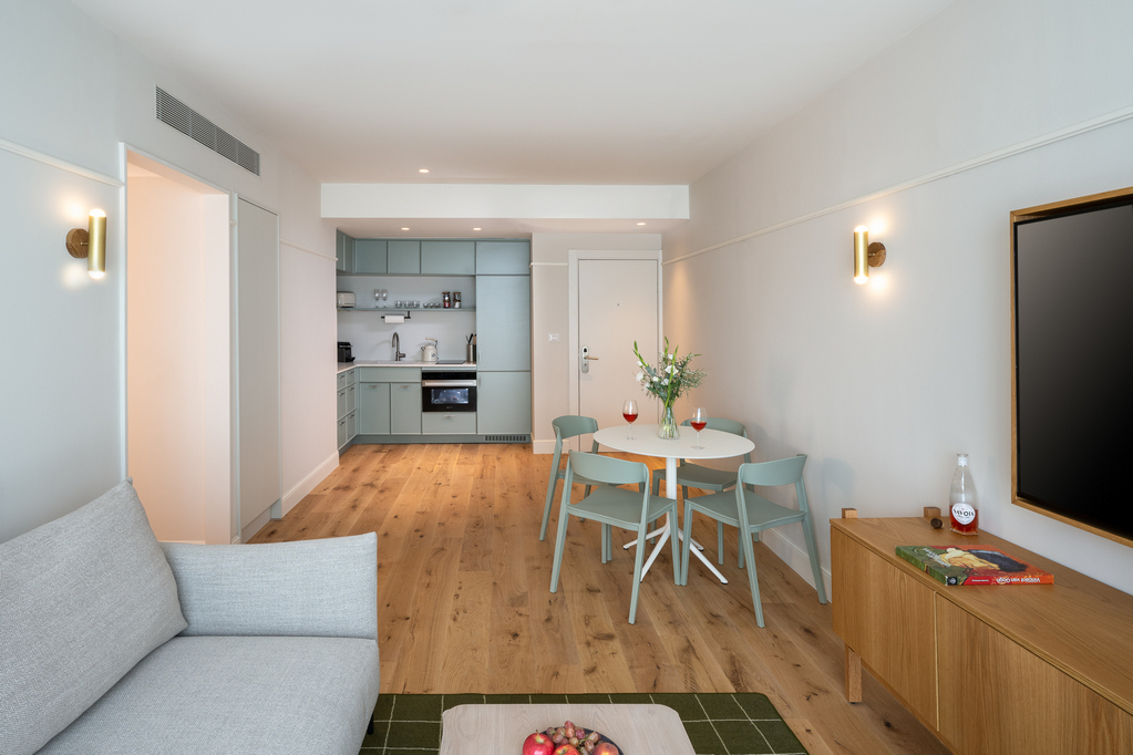 Modern kitchen in the Two-Bedroom with Sofa Bed at master Mazeh Tel Aviv, featuring a sleek dining table for a stylish and functional space.