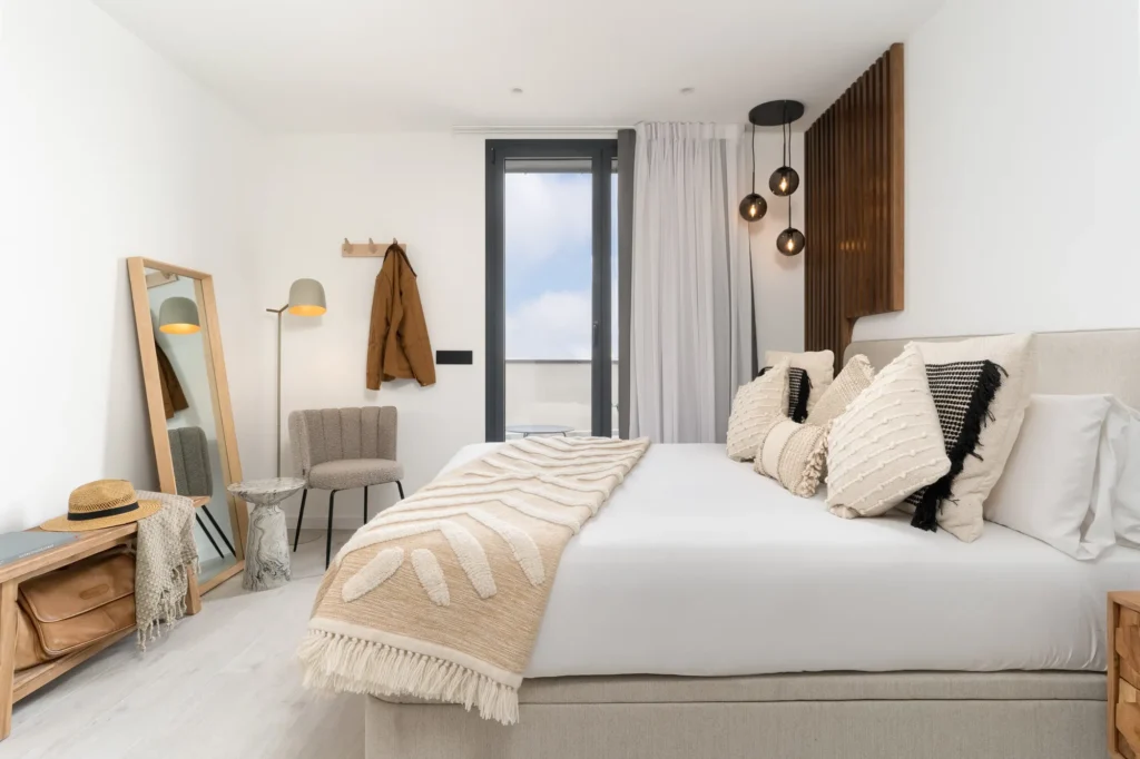 Serene bedroom with king-size bed, soft neutral decor, and private balcony access at master La Rambla’s Two Bedroom Apartment.