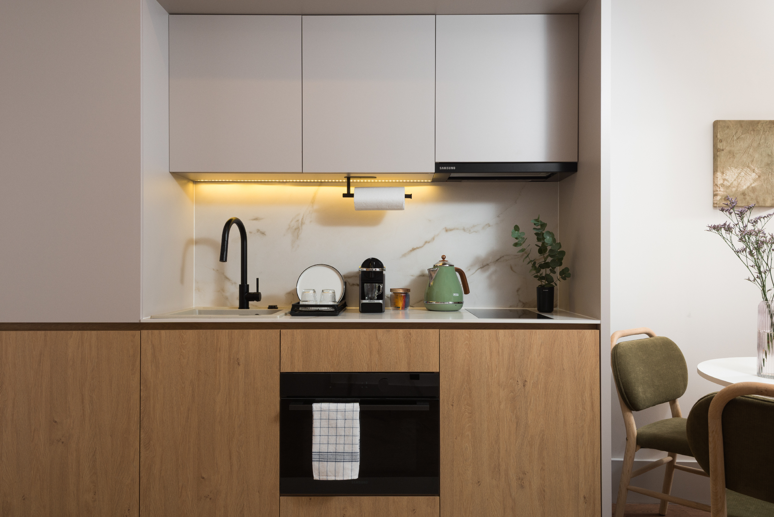 Fully equipped kitchenette in a studio apartment at master Wola Serviced Apartments with oven, sink, and coffee machine