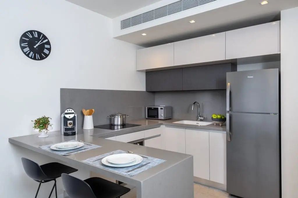Compact and functional kitchenette in the One-Bedroom Apartment at master Shenkin Tel Aviv, blending convenience with contemporary design.