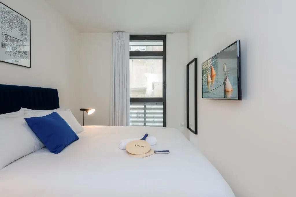 Comfortable bedroom in the One-Bedroom Apartment at master Shenkin Tel Aviv, featuring a plush bed and soft lighting for a relaxing stay.