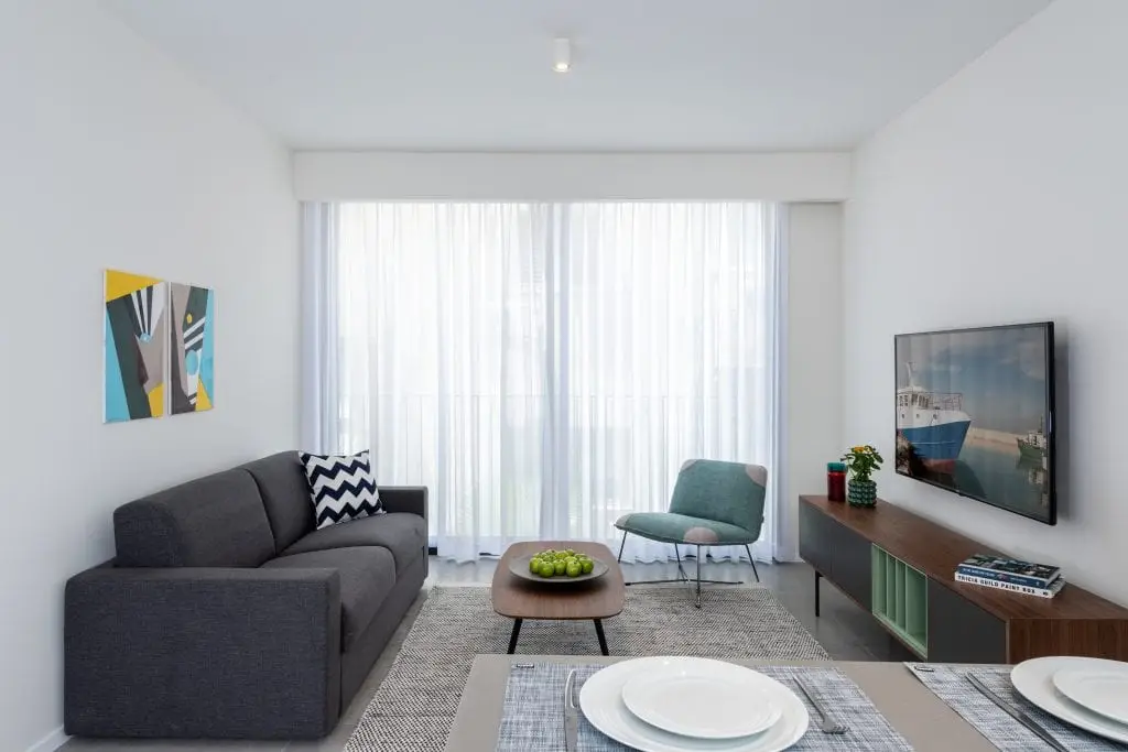 Bright and stylish living area in the One-Bedroom Apartment at master Shenkin Tel Aviv, featuring modern furnishings and a cozy ambiance
