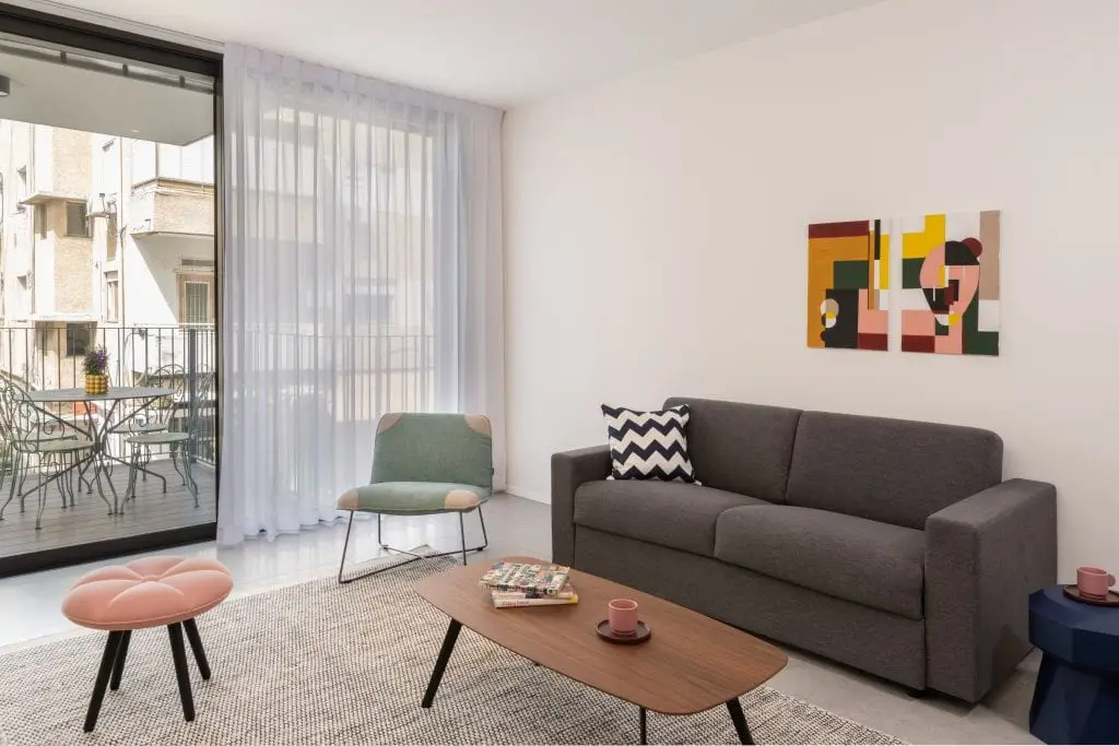Modern living area in the Three-Bedroom Apartment at master Shenkin Tel Aviv, featuring stylish furnishings and a cozy ambiance.