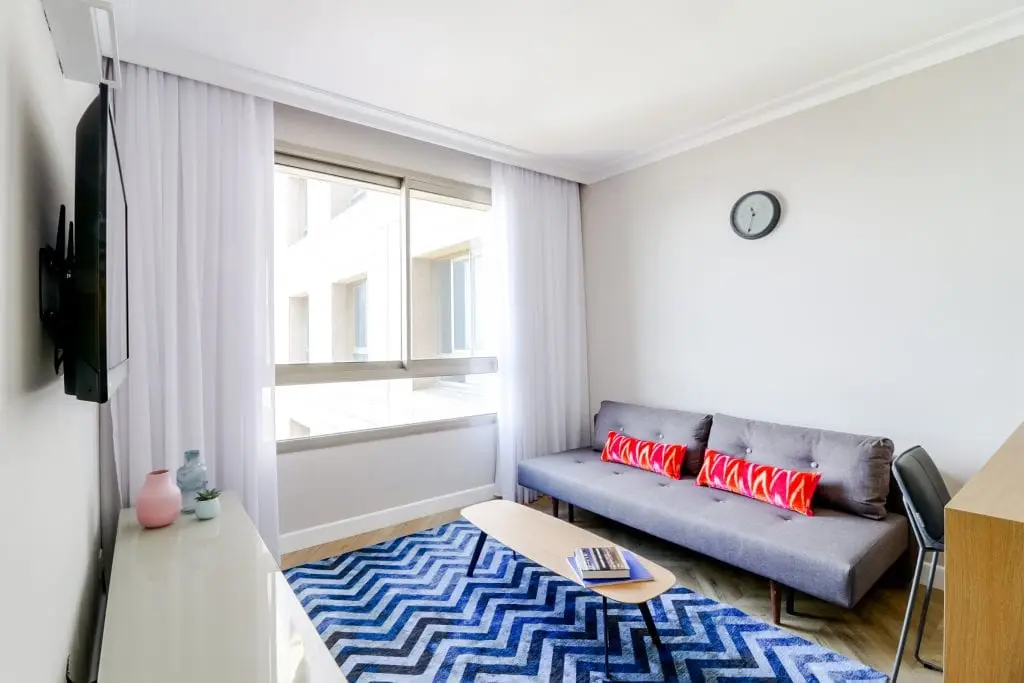 Bright and stylish living space in the One-Bedroom Seaview Apartment at master Haifa, offering a cozy seating area and contemporary decor