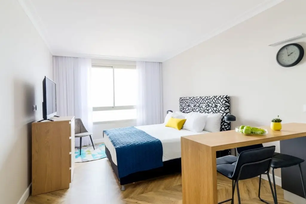 Bright and cozy bedroom at master Haifa, featuring a plush bed and stylish decor for a relaxing atmosphere.