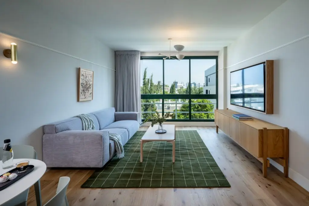 Bright and stylish living area at master Mazeh Tel Aviv, featuring a cozy sofa and sleek, modern decor.