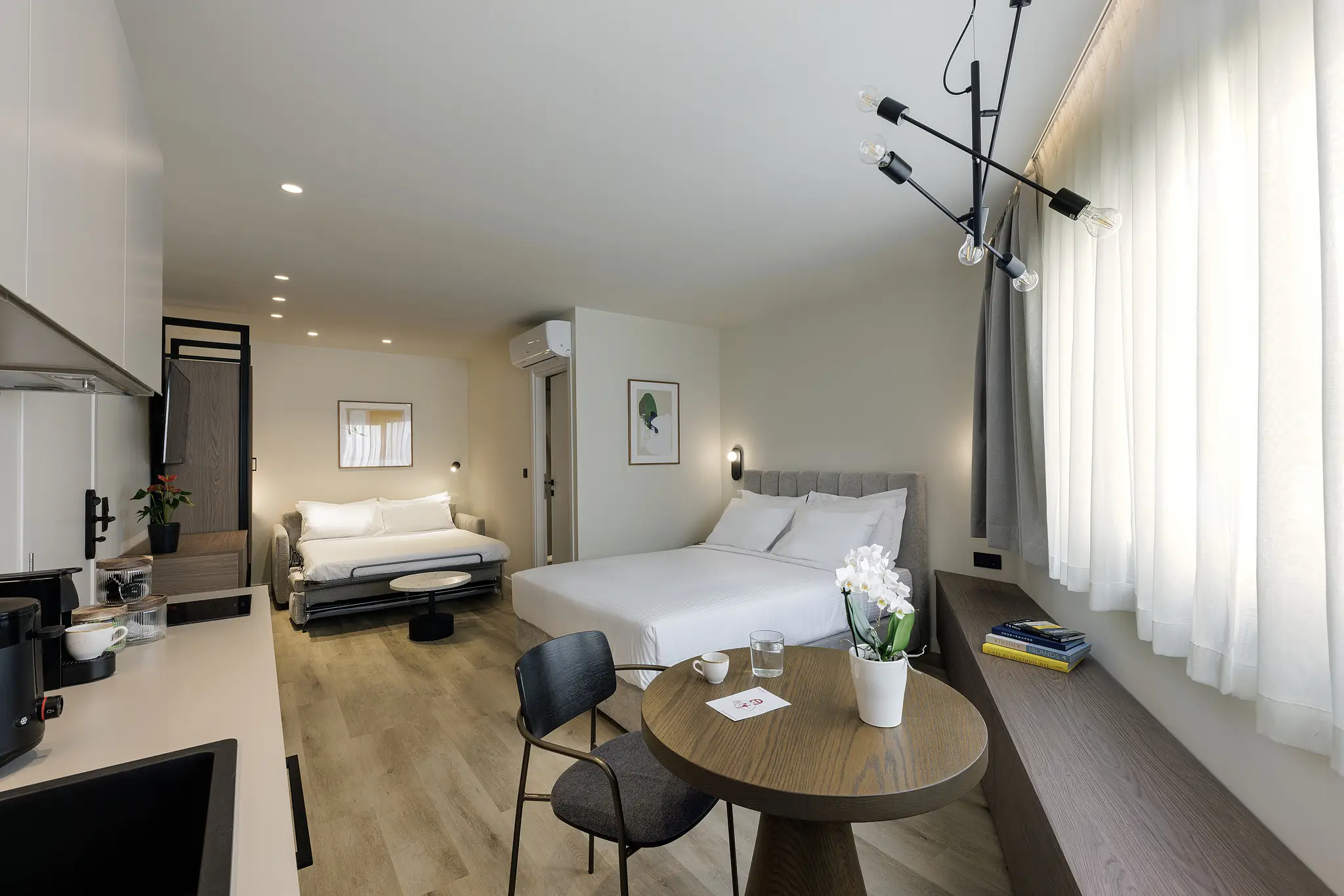 Modern studio at master Plaka Athens featuring a well-appointed bed and a stylish, functional layout.
