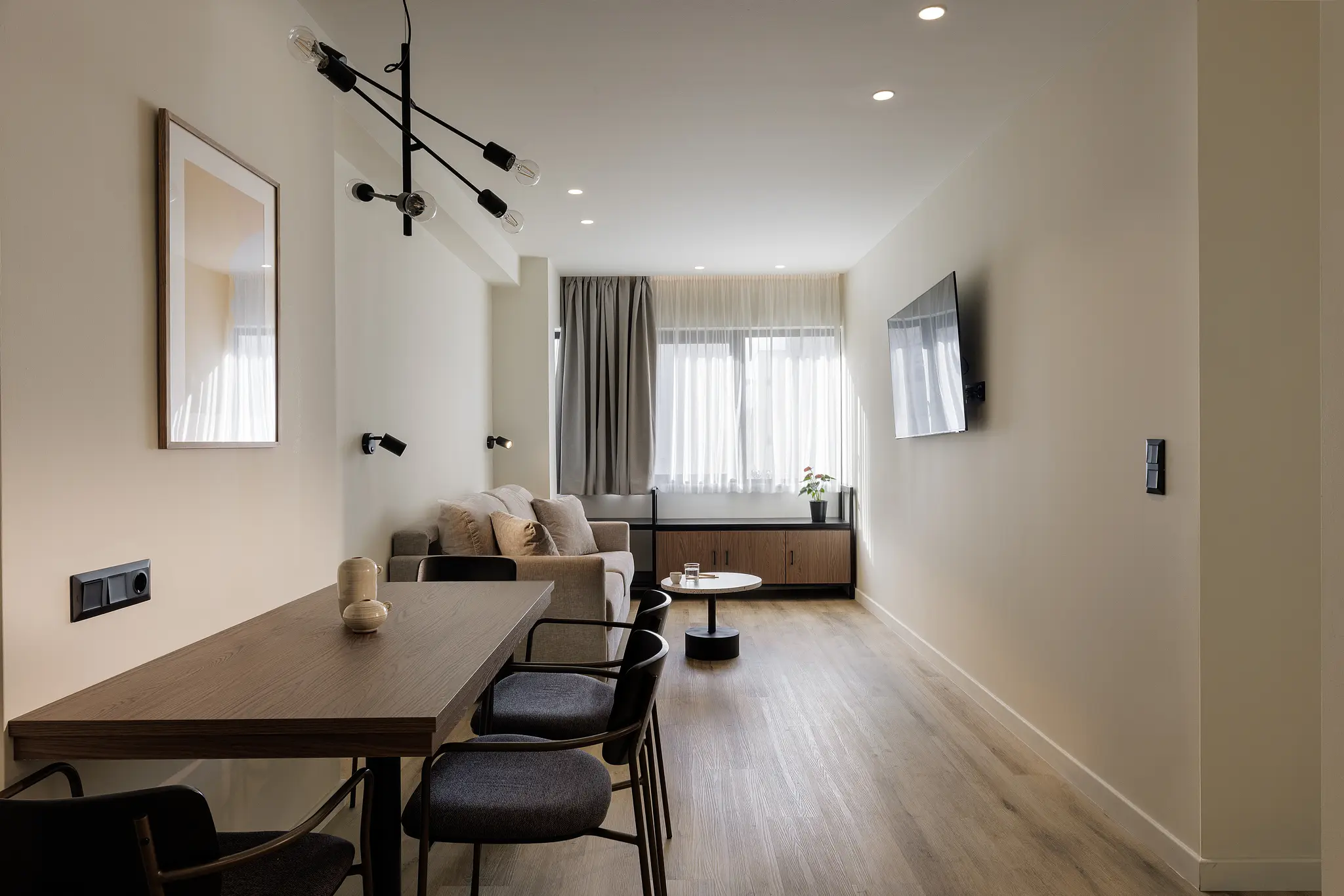 Stylish living area in the One Bedroom Apartment at master Plaka Athens, featuring a cozy sofa bed in its closed position for daytime lounging.