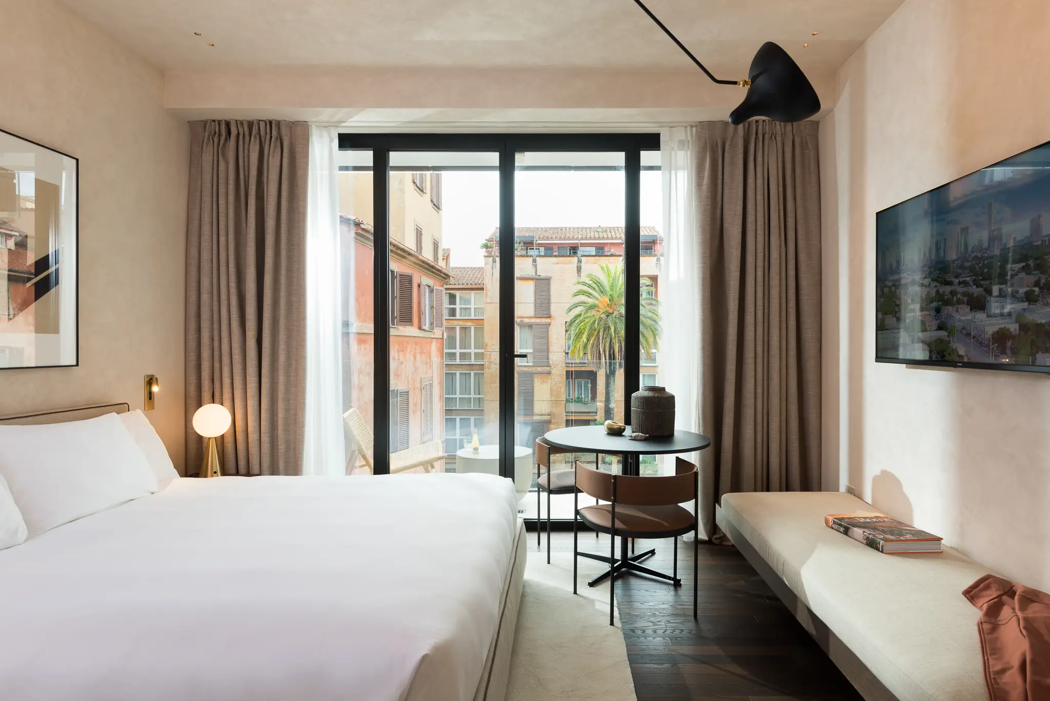 Bright and inviting bedroom in the Family Apartment with Balcony at master Trevi Rome, featuring a cozy bed and access to a private balcony with city views