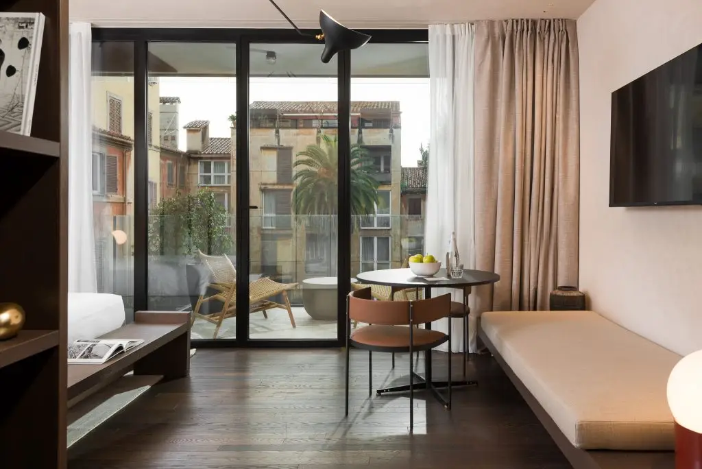 Bright and spacious living area in the Studio with Balcony at master Trevi Rome, seamlessly connecting to a private outdoor space.