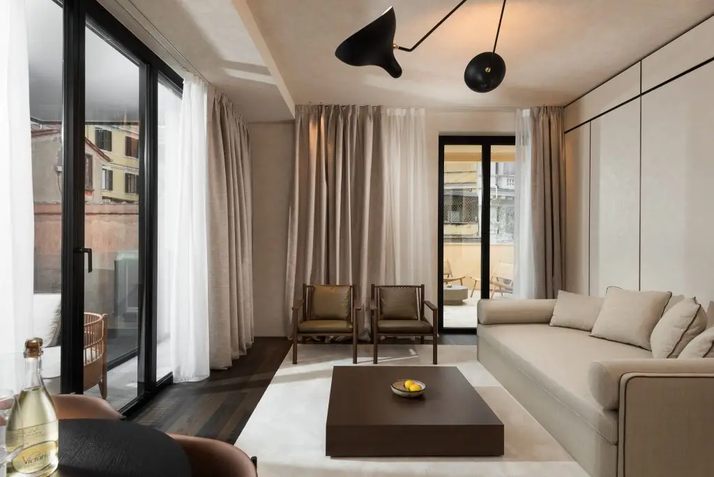 Bright and open living area in the One-Bedroom Apartment with Big Terrace at master Trevi Rome, featuring two entrances leading to the private balcony.