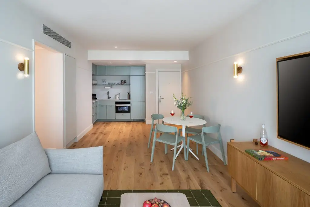 Modern kitchen in the One-Bedroom with Big Terrace & Sofa Bed at master Mazeh Tel Aviv, complemented by a sleek dining table for a stylish and functional space