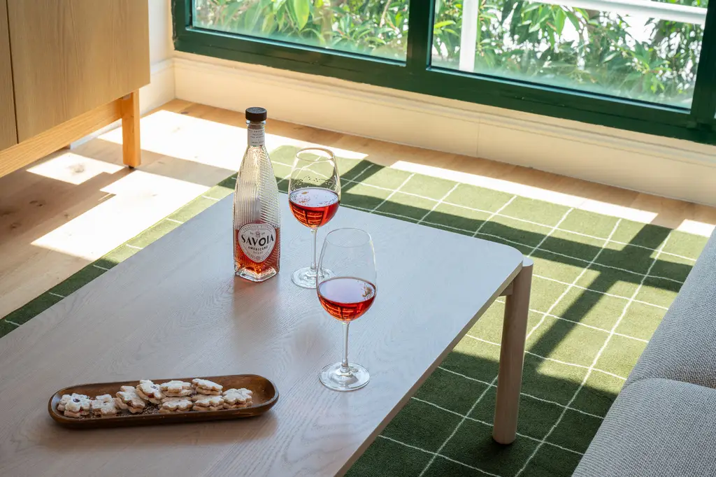 Elegant setting in the living area of the Two-Bedroom with Sofa Bed at master Mazeh Tel Aviv, featuring a table with a bottle of champagne and two glasses