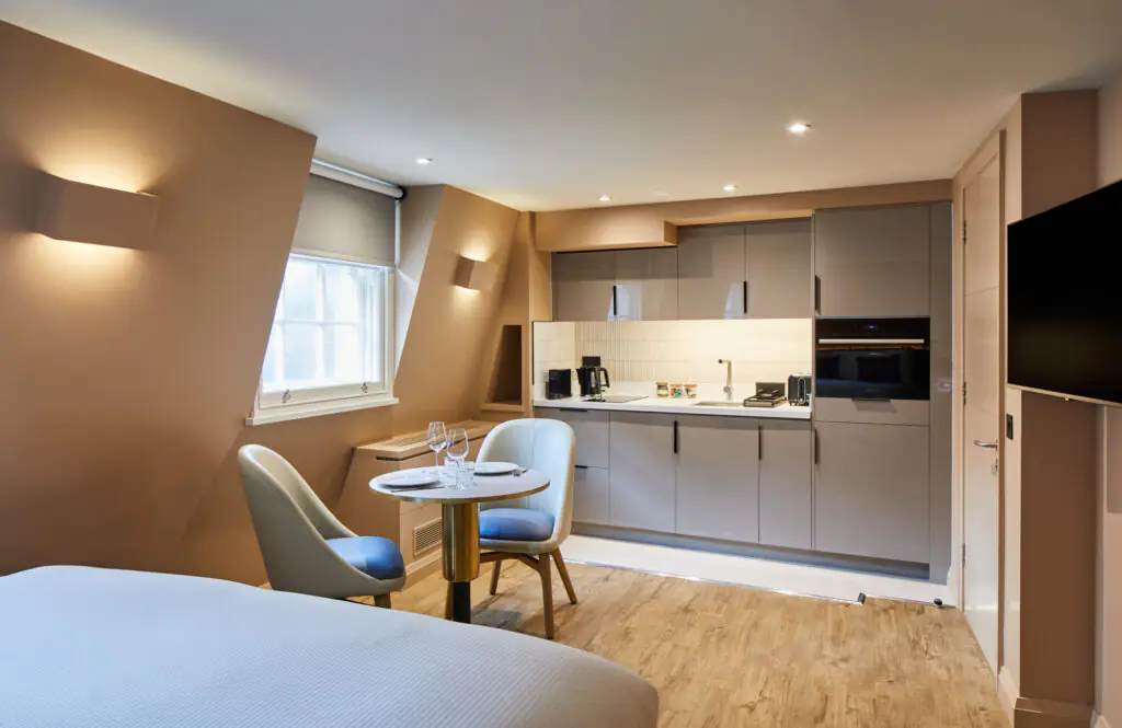 Modern studio at master Cannon London with a sleek kitchenette, small dining table, and soft neutral tones creating a cozy and functional space.
