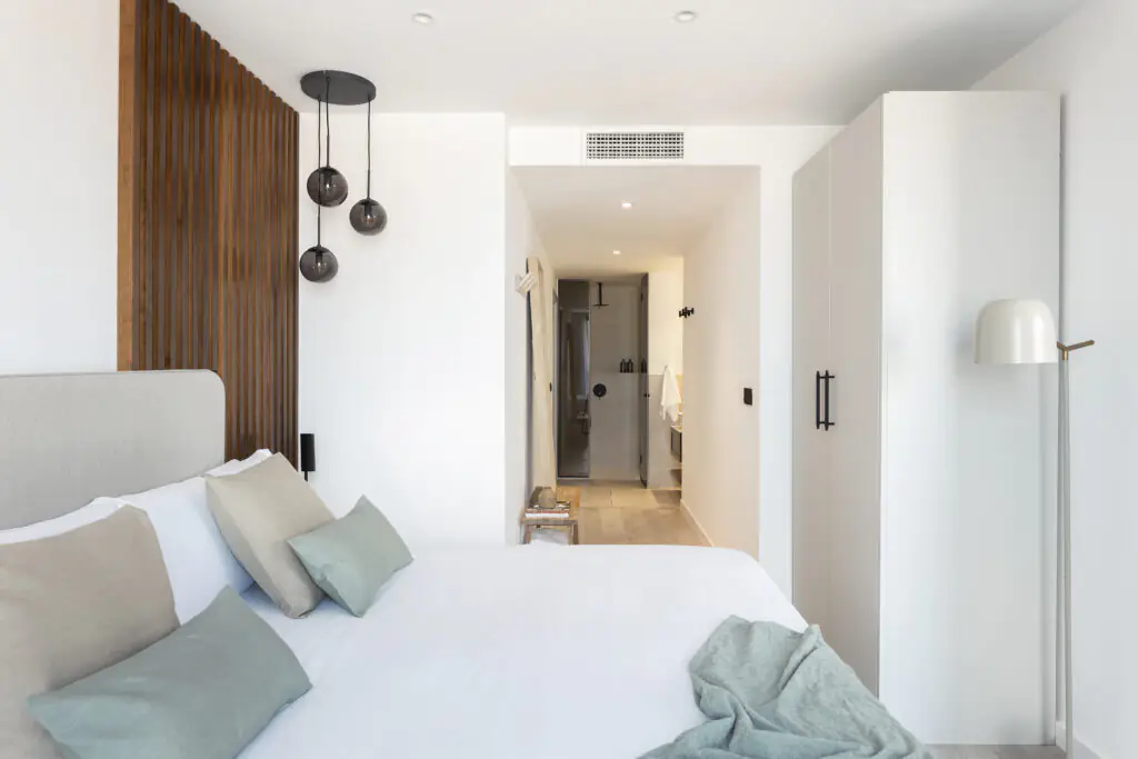 Two Bedroom Apartment at master La Rambla Barcelona with double bed, wood accent wall, pendant lights, and en-suite bathroom.